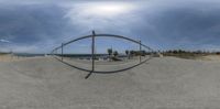 this is a view of a skate park at the beach through a circular mirror with a parking lot in the foreground