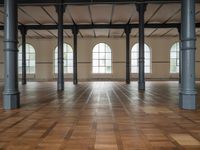 empty, large room with wood parquet floor and many windows and arches with wood parquet floors