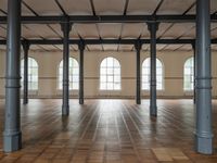 empty, large room with wood parquet floor and many windows and arches with wood parquet floors