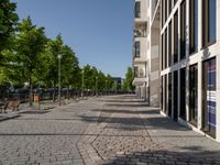 some benches in front of some buildings on the sidewalk with no cars in them but not visible