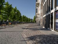 some benches in front of some buildings on the sidewalk with no cars in them but not visible