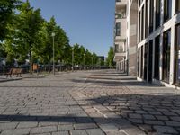 some benches in front of some buildings on the sidewalk with no cars in them but not visible