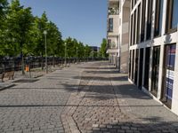 some benches in front of some buildings on the sidewalk with no cars in them but not visible