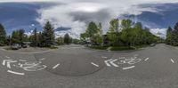 a street view of a cloudy day with trees and a sky in the background and a person riding a skateboard