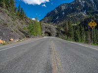 a road goes into a tunnel and through the hill to the other side of it