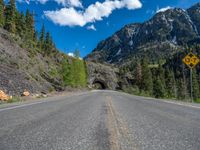 a road goes into a tunnel and through the hill to the other side of it