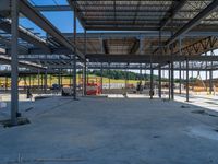 an empty warehouse with many floors and some workers standing around it with equipment on the floor