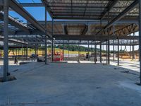 an empty warehouse with many floors and some workers standing around it with equipment on the floor