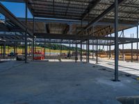 an empty warehouse with many floors and some workers standing around it with equipment on the floor