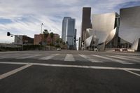 a white building is seen in the distance as cars travel around it on a city street