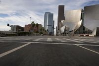 a white building is seen in the distance as cars travel around it on a city street