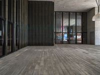 a modern looking lobby with wooden floors and large windows overlooking the city skyline in the day