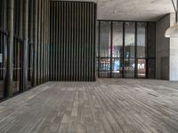 a modern looking lobby with wooden floors and large windows overlooking the city skyline in the day