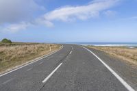 a large long road going down the beach towards the ocean with no vehicles in it