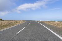 a large long road going down the beach towards the ocean with no vehicles in it