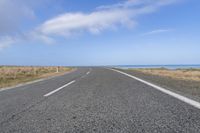 a large long road going down the beach towards the ocean with no vehicles in it