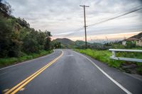 a road with a yellow sign on it in the daytime or the day time at sunset