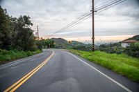 a road with a yellow sign on it in the daytime or the day time at sunset