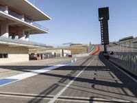 view of track on a sunny day with a bright blue sky overhead and the red track in front of it
