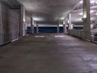 an empty parking garage has a ramp on one side and stairs and railings to the left