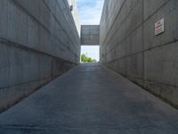 the empty parking lot in front of a wall with apartment buildings on it and a skateboarder on a ramp