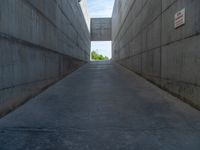 the empty parking lot in front of a wall with apartment buildings on it and a skateboarder on a ramp