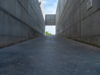 the empty parking lot in front of a wall with apartment buildings on it and a skateboarder on a ramp