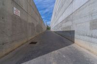 the empty parking lot in front of a wall with apartment buildings on it and a skateboarder on a ramp