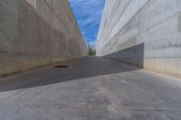 the empty parking lot in front of a wall with apartment buildings on it and a skateboarder on a ramp