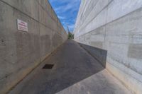 the empty parking lot in front of a wall with apartment buildings on it and a skateboarder on a ramp