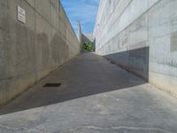 the empty parking lot in front of a wall with apartment buildings on it and a skateboarder on a ramp