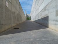 the empty parking lot in front of a wall with apartment buildings on it and a skateboarder on a ramp