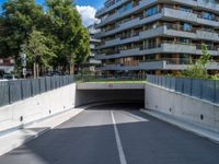 a large concrete tunnel in the middle of an empty street between two buildings with windows