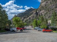 a big house with two fire trucks parked next to it and mountains in the background