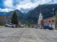 a big house with two fire trucks parked next to it and mountains in the background