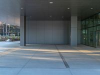 two grey blocks sitting next to a tall building on a sidewalk in front of grass