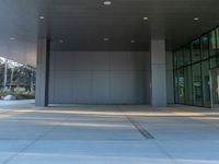 two grey blocks sitting next to a tall building on a sidewalk in front of grass