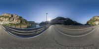 a picture taken in a fish - eye view of the road below a large mountain