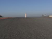 an empty track at a motorsports club with some red and white stripeing on it