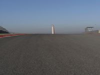 an empty track at a motorsports club with some red and white stripeing on it