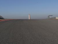 an empty track at a motorsports club with some red and white stripeing on it