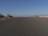 an empty track at a motorsports club with some red and white stripeing on it