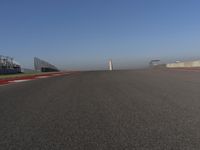 an empty track at a motorsports club with some red and white stripeing on it