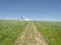 an empty grassy field that looks like it is growing in the air with a small white structure