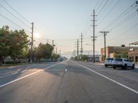 an empty street in front of a large red brick building on the other side of the road is a street light that has a line for motorists