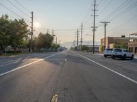 an empty street in front of a large red brick building on the other side of the road is a street light that has a line for motorists