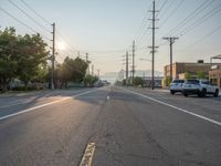 an empty street in front of a large red brick building on the other side of the road is a street light that has a line for motorists