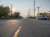 an empty street in front of a large red brick building on the other side of the road is a street light that has a line for motorists