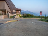 a building that has a bunch of windows on it at sunset with mountains in the background