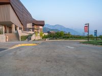 a building that has a bunch of windows on it at sunset with mountains in the background